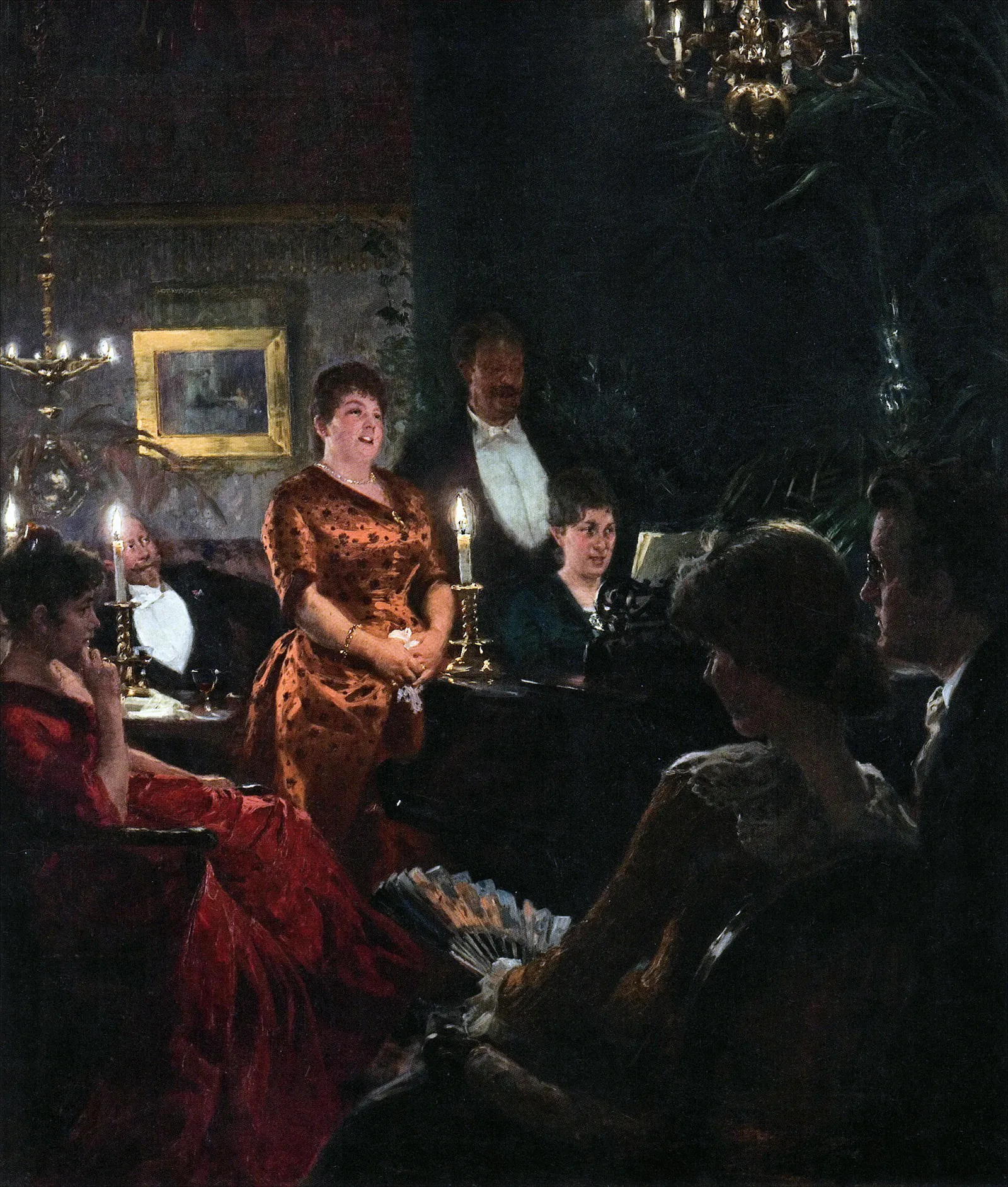 Two singers stand at a candlelit piano in a dark drawing room as guests look on.